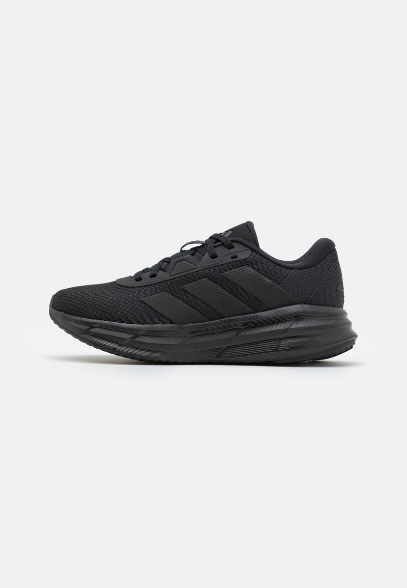 Chaussure de course athlétique noire avec tige en mesh, fermeture à lacets et semelle rembourrée avec trois bandes sur le côté.