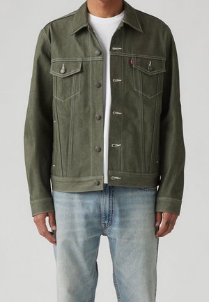Olijf groene denim jack met een knoopsluiting aan de voorkant, twee borstzakken, contrasterende stiksels en een klassieke kraag, gecombineerd met lichtblauwe jeans.
