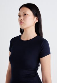 Navyblaues, eng anliegendes T-Shirt aus weicher Baumwolle mit Rundhalsausschnitt und kurzen Ärmeln, glatt und minimalistisch gestaltet.