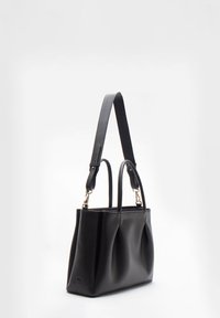 Zwarte leren stoffen tas met een gladde textuur, twee handvatten bovenaan en een afneembare schouderriem. Beschikt over een subtiele logo en een zacht geplooid ontwerp.