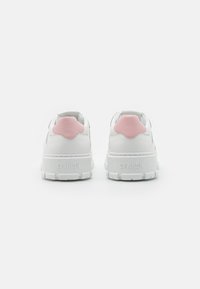 Weiße Sneakers mit einer strukturierten Gummisohle und einem sanften rosa Akzent an der Ferse. Verfügt über ein glattes Lederfinish und geprägte Markenlogos.