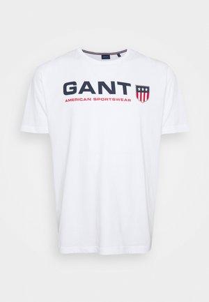 White short-sleeve T-shirt with "GANT AMERICAN SPORTSWEAR" text and a shield logo with stars and stripes on the chest.