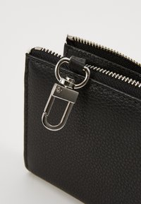 Black textured leather wallet featuring silver zippers and a metal clip attachment for secure closure and accessibility.
