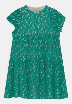 Robe verte à manches courtes en tissu léger avec un design à niveaux. Présente une fermeture à boutons et un motif de pois dorés métalliques.