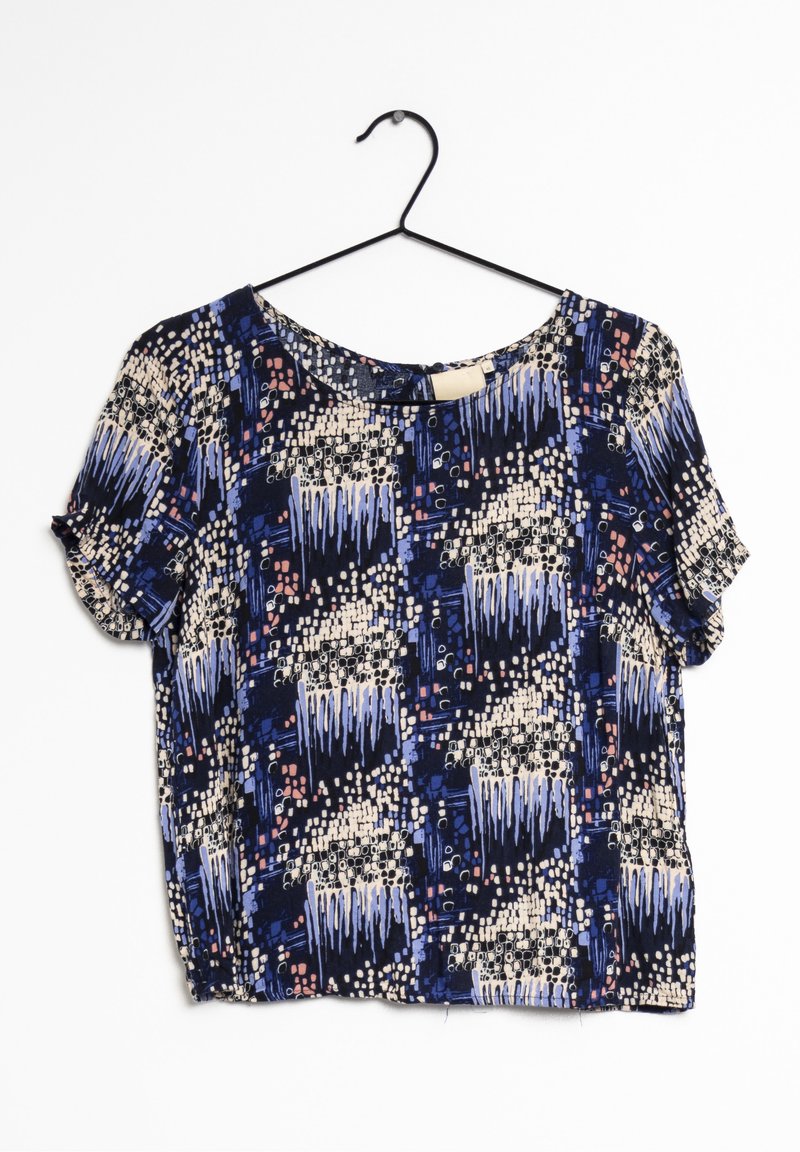 Blusa a maniche corte in tessuto blu scuro con motivo grafico di forme blu chiaro, rosa e bianche; scollatura rotonda, vestibilità rilassata.