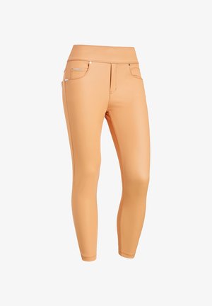 Leggings de couleur pêche à taille haute, fabriqués à partir d'un matériau lisse et extensible. Comprend des poches décoratives et des accents en matériel subtil.