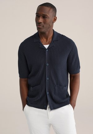 Marineblauwe korte mouw cardigan gemaakt van getextureerde gebreide stof, met een knoopsluiting aan de voorkant, twee zakken aan de voorkant en een klassiek kraagontwerp.