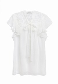 Hvit kjole med flagrende ermer, blonde øverste del og sløyfe i halsen. Har teksturerte prikkede punkter over hele stoffet.