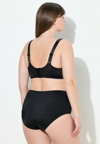 Czarny komplet bielizny składający się z gładkiego, eleganckiego biustonosza z koronkowym wykończeniem z tyłu oraz wysokich majtek w pasującym stylu. Teksturowane ramiączka zapewniają wsparcie.