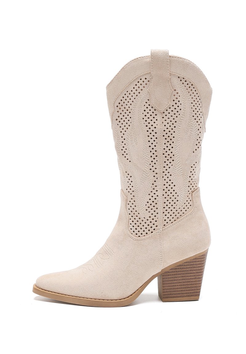 Bota vaquera de ante beige con punta afilada, diseño recortado, costuras intrincadas y tacón apilado. Superficie texturizada y acentos western.