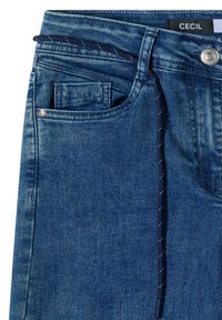 Blue denim jeans with a front pocket showing a coin pocket, metal button, belt loop, and a dark blue drawstring with white dots.