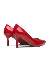 Scarpe con tacco alto in vernice rossa, con punta affilata e sottile tacco a stiletto. Superficie liscia e sottile dettaglio con intaglio alla tomaia.