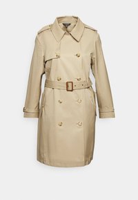 Beige dubbelknäppt trenchcoat med skärp, knappade axelklaffar, två framfickor och långa ärmar på vit bakgrund.