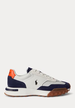 Sneaker in camoscio bianco e blu navy con linguetta al tallone arancione, suola in gomma marrone e logo del giocatore di polo nero sul lato.