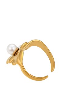 Anello d'oro con una fascia aperta, caratterizzato da una perla bianca incastonata in dettagli in oro a forma di petali che ricordano un fiore.