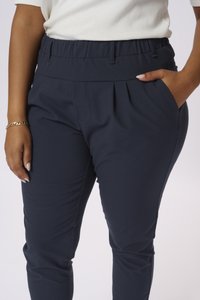 Pantaloni elasticizzati blu navy con tasche, caratterizzati da una texture liscia e dettagli plissettati anteriori, progettati per comfort e facilità di movimento.