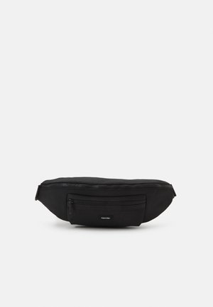 Marsupio in tessuto nero con design elegante, dotato di un ampio scomparto principale con chiusura zip e una tasca frontale con zip. Logo del brand visibile in modo discreto.