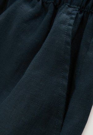 Tessuto blu scuro con una finitura tessuta e testurizzata; dettaglio con vita arricciata; bordi lisci; materiale leggero.