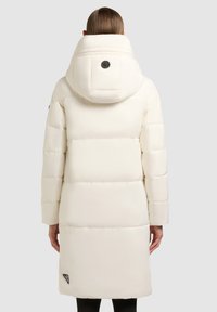 Duvet jakna u off-white boji, s visokim ovratnikom i velikom kapuljačom. Ima gumirane dijelove i detalj s logotipom sa strane. Glatka, sjajna tkanina.