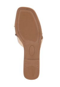 Semelle de sandale beige clair avec une surface en caoutchouc texturé, présentant un design plat et un petit accent circulaire près du centre.