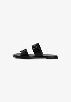 Black slide sandals with two adjustable straps featuring rectangular metal buckles, smooth leather material, and flat rubber sole.