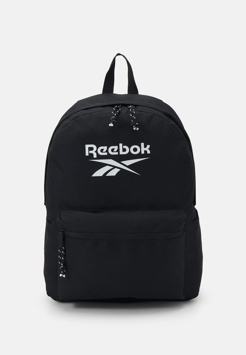 Črna nahrbtnik ima trdno zasnovo, izstopajoč bel logotip Reebok, nastavljive naramnice in sprednji žep z zadrgo, okrašen z oblački.