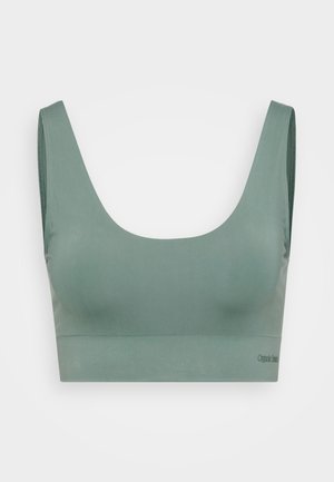Groene naadloze bh van zacht materiaal. Heeft brede banden en een lage ronde halslijn. Merkennaam weergegeven aan de onderkant.