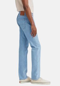 Jeans in denim azzurro chiaro con un design a gamba dritta, cinque tasche e una texture sbiadita. Cuciture rinforzate e una toppa sul retro.