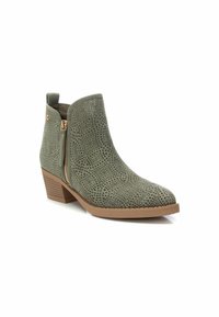 Botín verde perforado hasta el tobillo con punta redondeada, cremallera lateral, tacón apilado y material texturizado similar al ante.