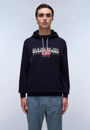 Felpa blu navy con tasca frontale e cordini bianchi, caratterizzata da un logo grafico con una bandiera rossa e bianca. Texture morbida, vestibilità casual.