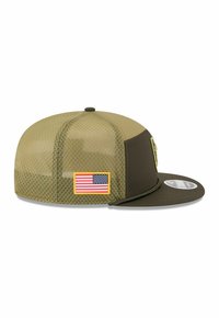 Olivgrüner Cap mit Netzpaneelen, flachem Schirm und gelb umrandetem amerikanischen Flaggenpatch. Verfügt über eine glatte Textur und ein strukturiertes Design.