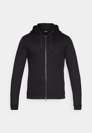 Felpa nera con zip realizzata in tessuto jersey, dotata di cappuccio, tasche frontali e una patch logo testurizzata sulla parte sinistra del petto.