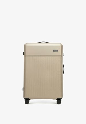 Harde koffer in metallic goud, met verticale ribbelstructuur, bovenhandvat en vier zwarte wielen voor mobiliteit. Merkenlabel zichtbaar.