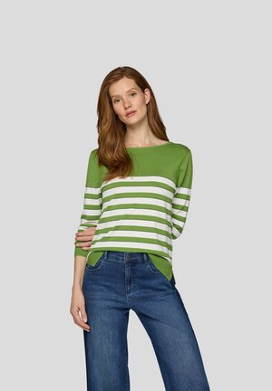 Grün-weiß gestreifter Pullover mit lockerer Passform, Rundhalsausschnitt und Dreiviertelärmeln, kombiniert mit blauen Jeans in einem lässigen Stil.