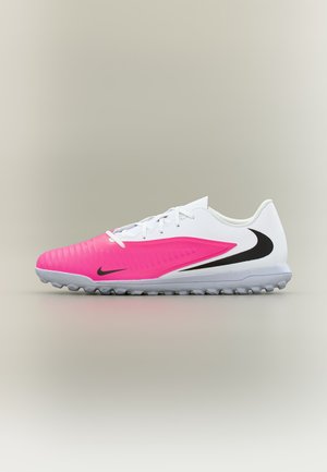 Pantof sport Nike alb și roz cu crampoane pe talpă, sigle Nike Swoosh negre și șireturi albe, prezentat din profil pe un fundal neutru.
