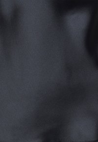 Tela de satén negro con una textura suave y brillante, que exhibe variaciones sutiles de luz y sombra en toda su superficie.