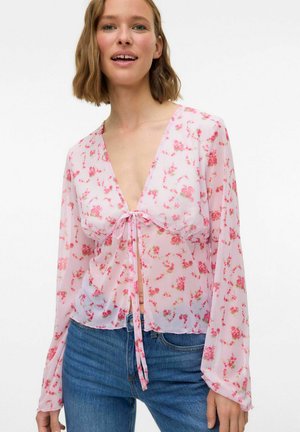 Blommig blus i lätt, genomskinlig rosa tyg med långa ärmar, djup V-ringning och knytframställning. Har små flerfärgade blommor.