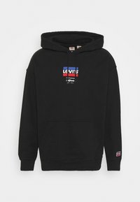 Sweat à capuche noir avec une poche avant, une capuche à cordon et un logo Levi's imprimé en rouge, blanc et bleu. Tissu doux avec des poignets côtelés.