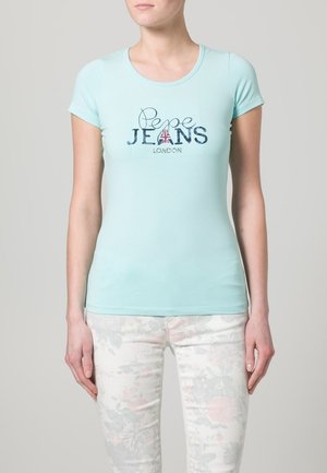 Jasnoniebieska przylegająca koszulka z krótkimi rękawami i okrągłym dekoltem. Z przodu znajduje się napis "Pepe JEANS LONDON" z czerwonym akcentem w postaci flagi Union Jack.
