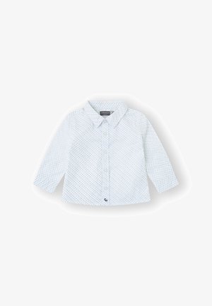 Camisa blanca para bebé con mangas largas, lunares azules, cierre de botones en la parte delantera y pequeño bordado de "CH" cerca del dobladillo.