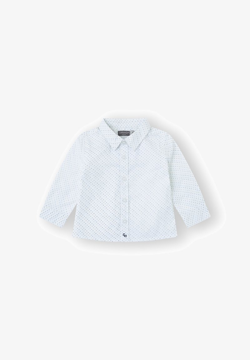 Camisa blanca para bebé con mangas largas, lunares azules, cierre de botones en la parte delantera y pequeño bordado de "CH" cerca del dobladillo.