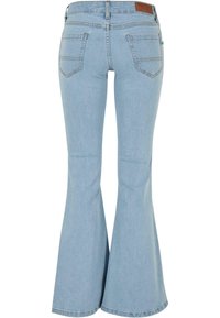 Lichtblauwe flared jeans van denim. Beschikt over een hoge taille, twee achterzakken en een bruine leren merkembleem op de taille.