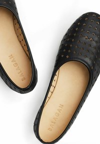 Zapatos negros de piel sin cordones con un diseño perforado en formas de diamante. El interior es beige y lleva el nombre de la marca "BALAGAN" en relieve.
