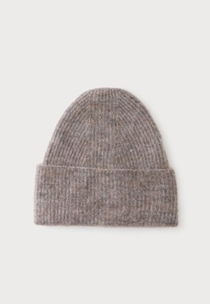 Blødt ribstrikket beanie i en lys brun farve med opbukket kant, vist på en ensfarvet lys baggrund.