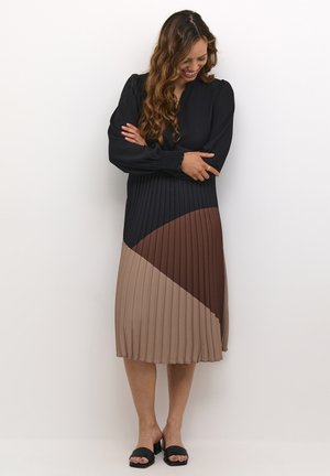 Black long-sleeve dress with a pleated skirt featuring a diagonal color block in brown and taupe. Smooth texture with a relaxed fit.