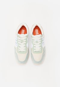 Baskets vertes et blanches en matériau mesh et daim ; bout rond, semelle texturée et lacets blancs ; semelle intérieure orange avec logo.
