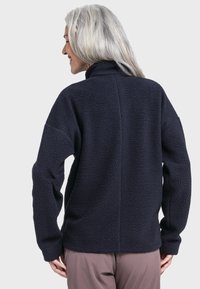 Marineblauer Fleece-Pullover mit hohem Kragen, strukturiertem Material, schrägen Schultern und langen Ärmeln. Verfügt über eine gerade Rückennaht und eine entspannte Passform.