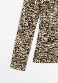 Indumento a maniche lunghe con un motivo a maglia grossa e testurizzata in filati beige e marrone scuro alternati, mostrato su sfondo bianco semplice.