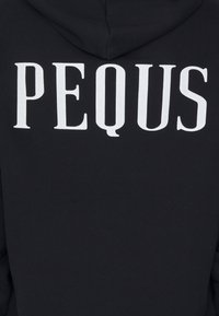 Felpa nera con cappuccio che presenta la parola "PEQUS" in grandi lettere bianche sul retro, realizzata in un morbido tessuto testurizzato.
