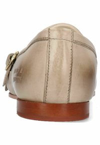 Mocassini beige in pelle con finitura liscia, suola piatta in legno e dettaglio in ottone dorato sul lato. Cuciture sottili sul retro.